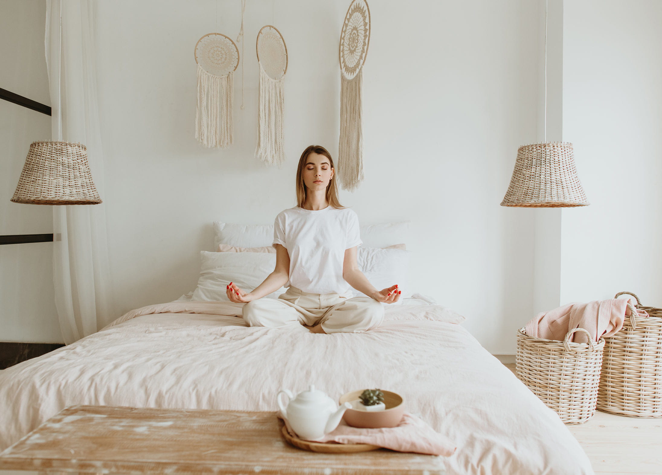 A woman meditating on a bed